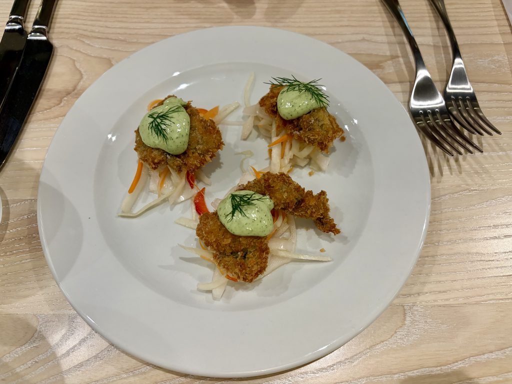Three crispy Dorset oysters with jalapeño mayonnaise and dill on a bed of pickled vegetables