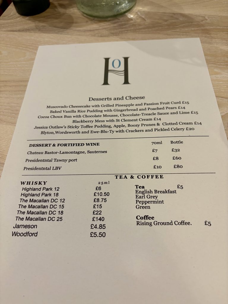 Desserts and cheese menu with dessert wines, whisky, tea and coffee, on a pale wooden table